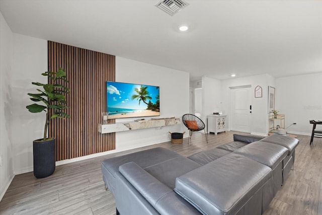 living room with baseboards, visible vents, wood finished floors, and recessed lighting