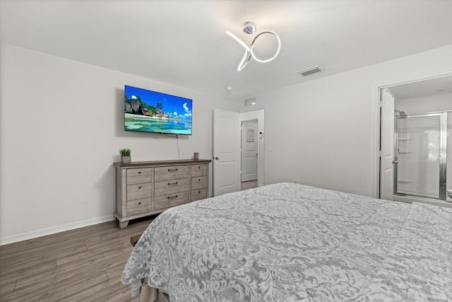 bedroom featuring visible vents, baseboards, and wood finished floors