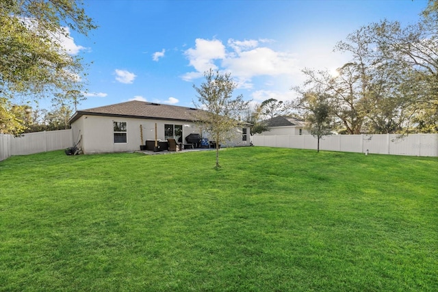 back of house featuring a patio area, a fenced backyard, a yard, and stucco siding