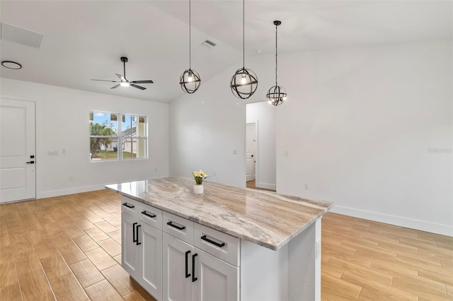 kitchen with visible vents, light wood-style flooring, a kitchen island, open floor plan, and pendant lighting