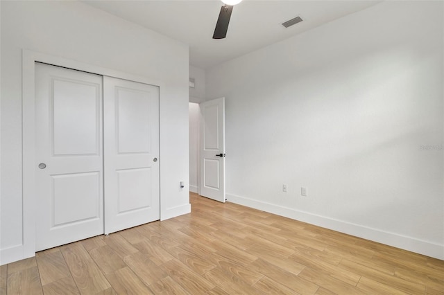 unfurnished bedroom featuring a closet, visible vents, light wood-style floors, a ceiling fan, and baseboards