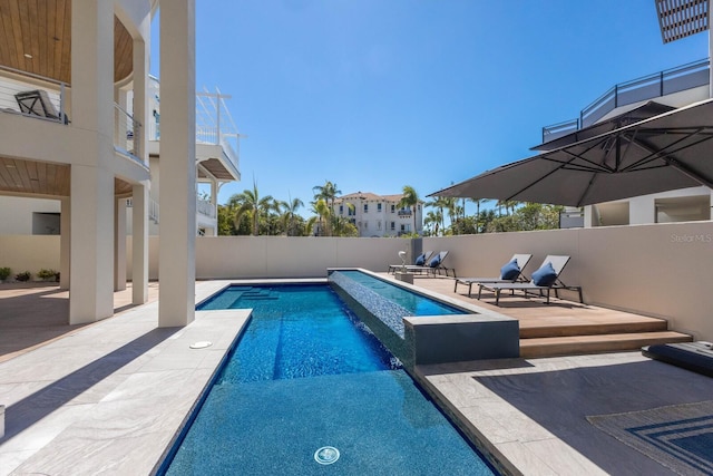 view of pool with a patio, a pool with connected hot tub, and fence