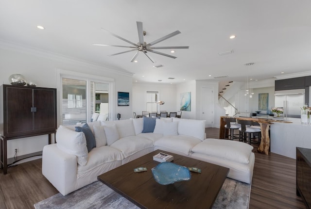 living room featuring ceiling fan, stairs, ornamental molding, recessed lighting, and wood finished floors