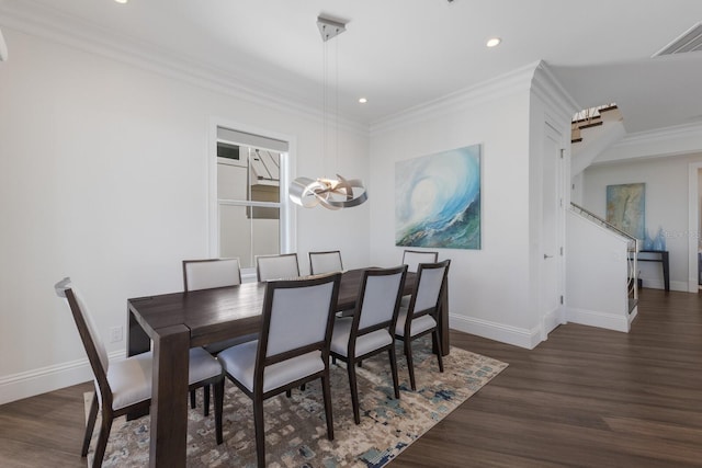 dining area featuring baseboards, wood finished floors, and crown molding