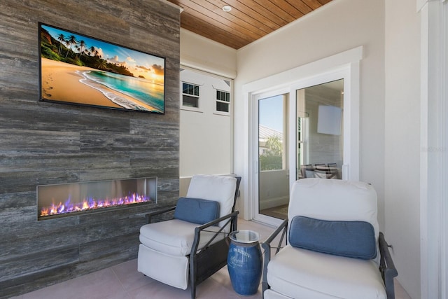 sitting room with a glass covered fireplace, tile patterned floors, and wood ceiling