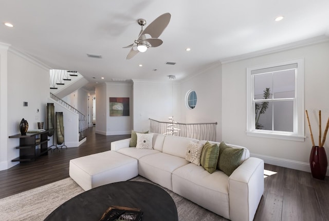 living area with visible vents, wood finished floors, crown molding, ceiling fan, and stairs