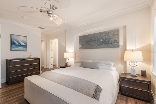 bedroom with visible vents, baseboards, ornamental molding, a ceiling fan, and dark wood-style flooring