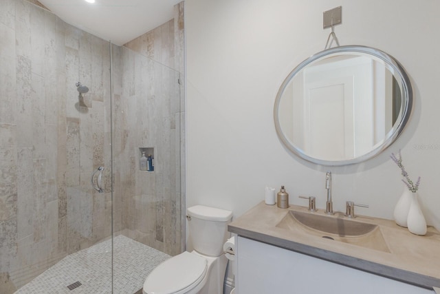 bathroom with a stall shower, toilet, and vanity