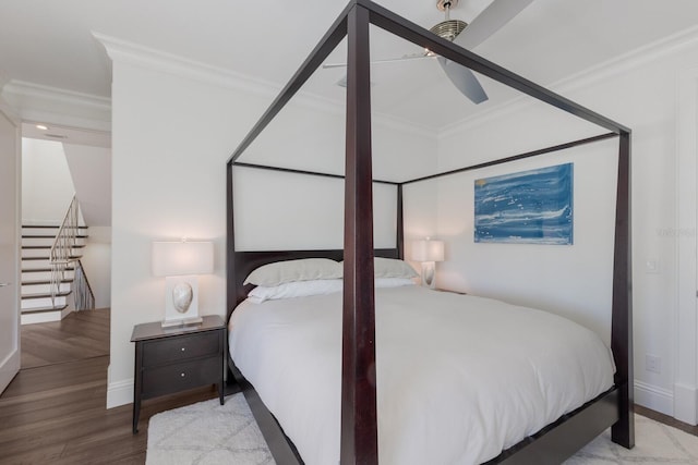 bedroom featuring ceiling fan, wood finished floors, baseboards, and ornamental molding