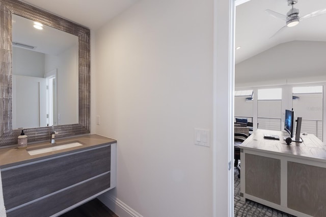 bathroom featuring baseboards, vanity, a ceiling fan, and vaulted ceiling