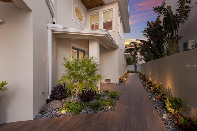 view of side of home with stucco siding and a fenced backyard