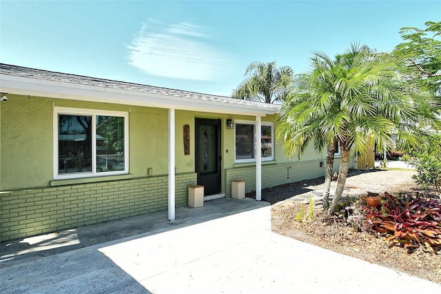 view of front of property featuring stucco siding and brick siding