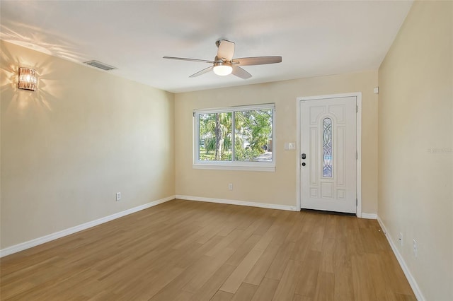 entrance foyer featuring light wood finished floors, a ceiling fan, visible vents, and baseboards