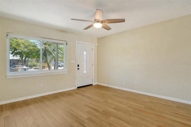 foyer with light wood-style floors, baseboards, and a ceiling fan