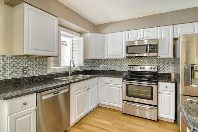 kitchen featuring stainless steel appliances, light wood-style floors, white cabinetry, and a sink