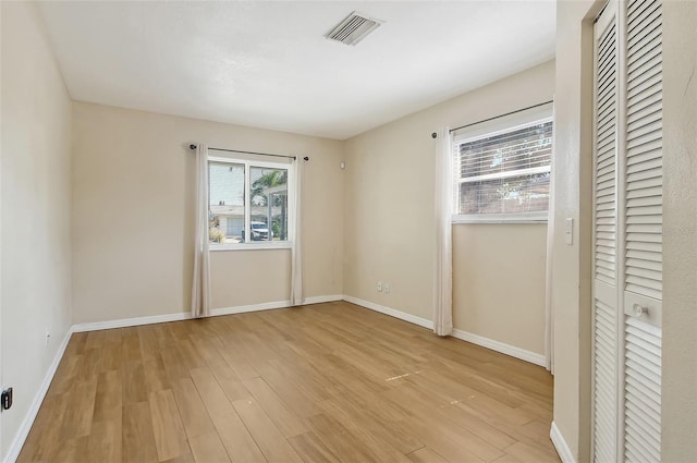 interior space with light wood finished floors, visible vents, and baseboards