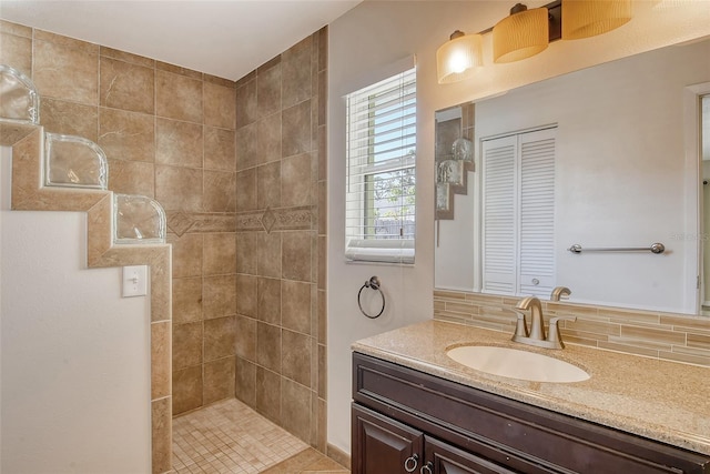 bathroom featuring a closet, backsplash, vanity, and walk in shower