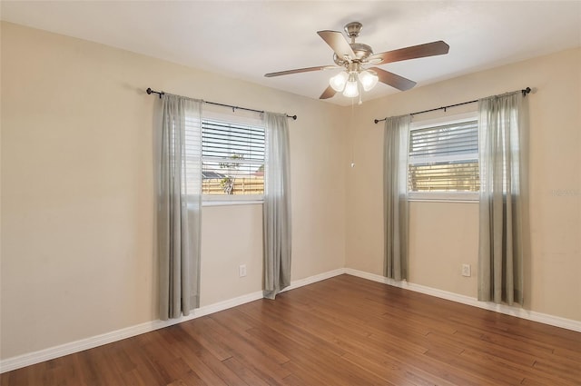 spare room with plenty of natural light, baseboards, ceiling fan, and wood finished floors