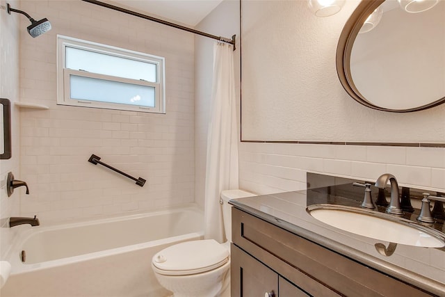 full bathroom with shower / tub combo with curtain, tile walls, a textured wall, toilet, and vanity