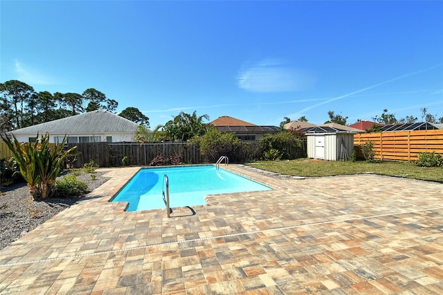 view of swimming pool featuring a patio, a storage unit, an outdoor structure, and a fenced backyard