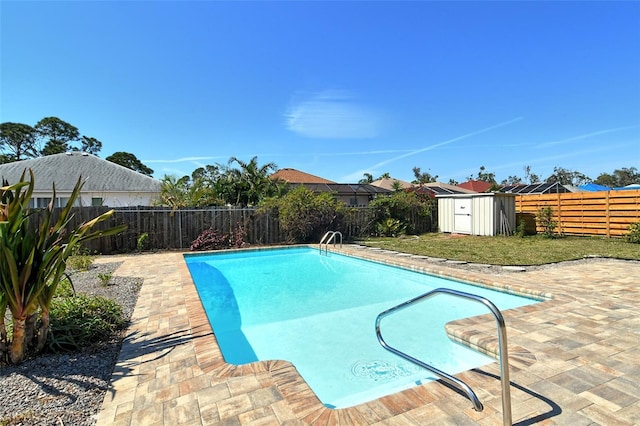 view of swimming pool featuring a fenced in pool, an outbuilding, a patio area, a shed, and a fenced backyard