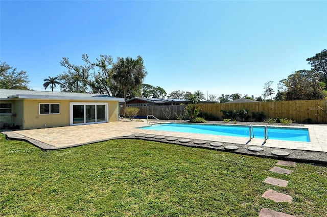 view of swimming pool featuring a patio, a lawn, a fenced backyard, and a fenced in pool