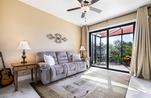 living room with ceiling fan, a sunroom, and baseboards