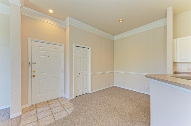 entryway with recessed lighting, ornamental molding, and light colored carpet