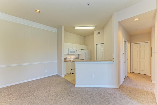 kitchen with light carpet, white appliances, white cabinetry, and recessed lighting