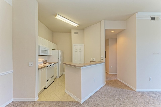 kitchen with white appliances, visible vents, baseboards, light colored carpet, and white cabinetry