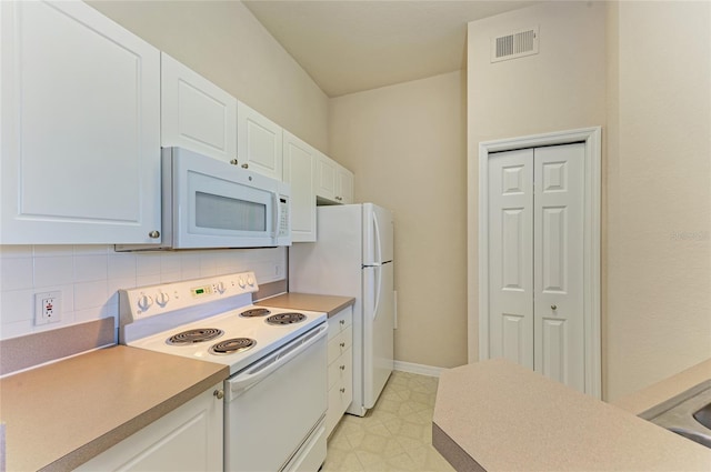 kitchen with white appliances, tasteful backsplash, visible vents, and white cabinets