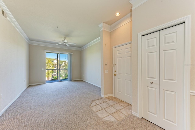 entryway with ornamental molding, light colored carpet, and baseboards