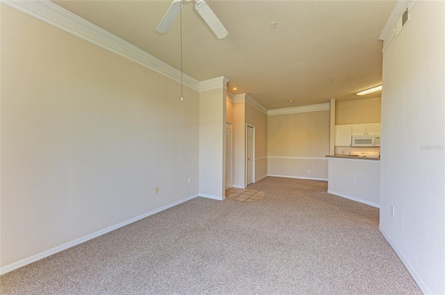 spare room with visible vents, ornamental molding, light carpet, ceiling fan, and baseboards