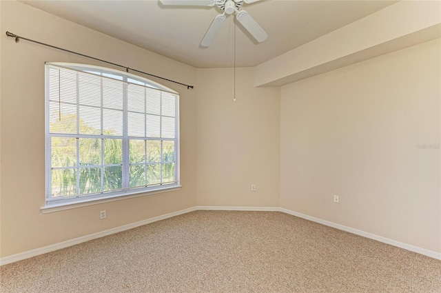 spare room featuring ceiling fan, baseboards, and light colored carpet