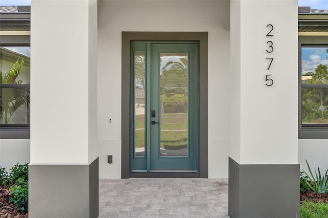 view of exterior entry featuring stucco siding