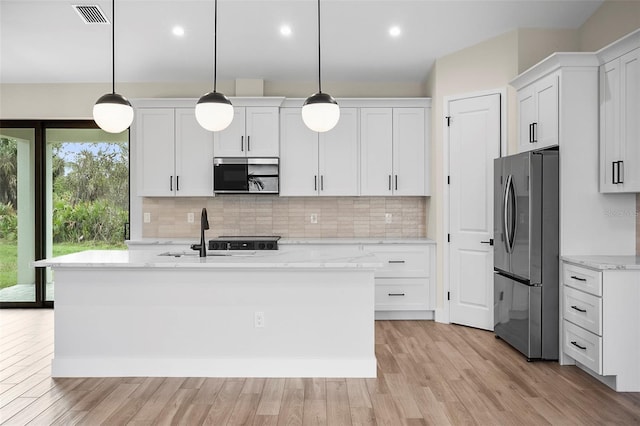 kitchen featuring visible vents, a sink, appliances with stainless steel finishes, white cabinetry, and backsplash