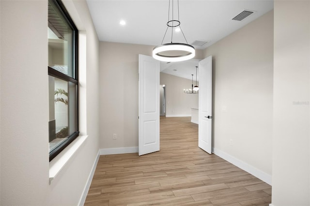 interior space with light wood finished floors, visible vents, and baseboards