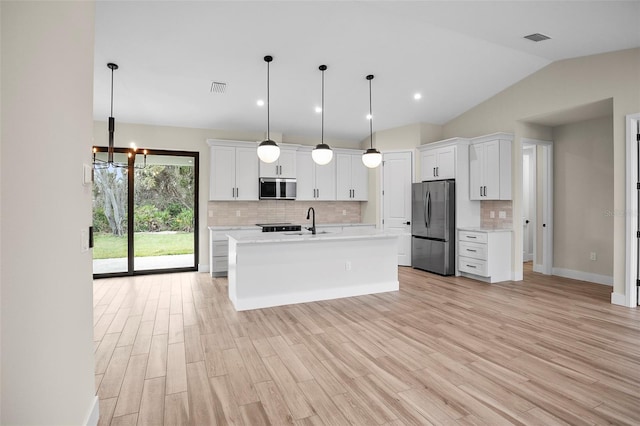 kitchen featuring a sink, stainless steel appliances, white cabinets, light wood finished floors, and light countertops