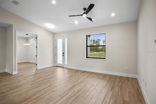 unfurnished room featuring light wood-type flooring, visible vents, a ceiling fan, baseboards, and lofted ceiling