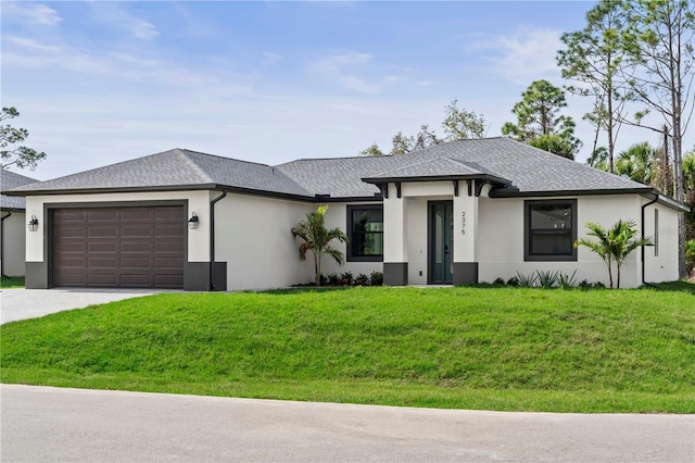 prairie-style house with driveway, a front yard, a garage, and a shingled roof