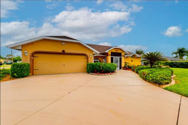 ranch-style house featuring a garage, concrete driveway, and stucco siding