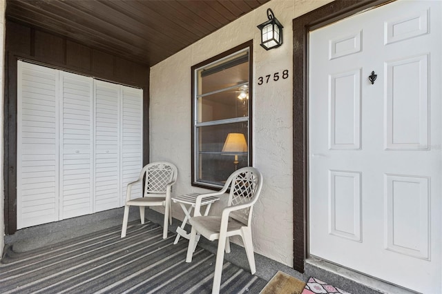 property entrance featuring a porch and stucco siding