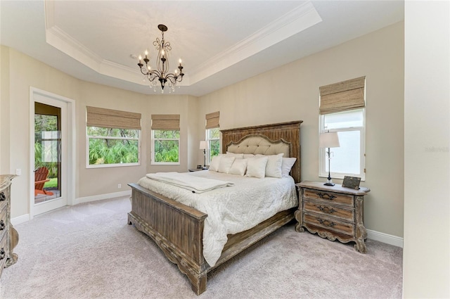 bedroom featuring a tray ceiling, light carpet, and multiple windows