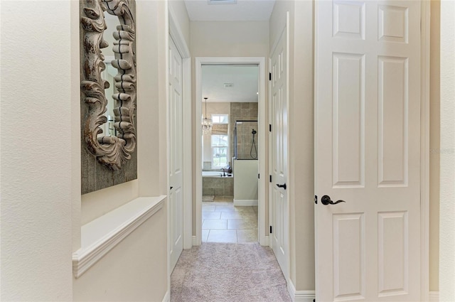 hall featuring light carpet, light tile patterned floors, and visible vents