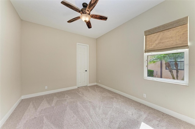 carpeted empty room featuring ceiling fan and baseboards