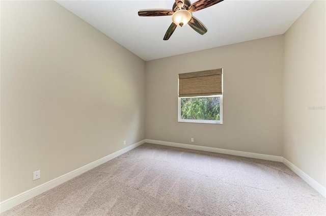 empty room featuring a ceiling fan, light colored carpet, and baseboards