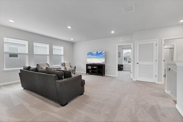 living area with recessed lighting, visible vents, and light colored carpet