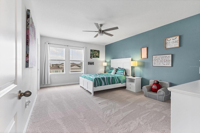 bedroom featuring a ceiling fan, light colored carpet, and baseboards