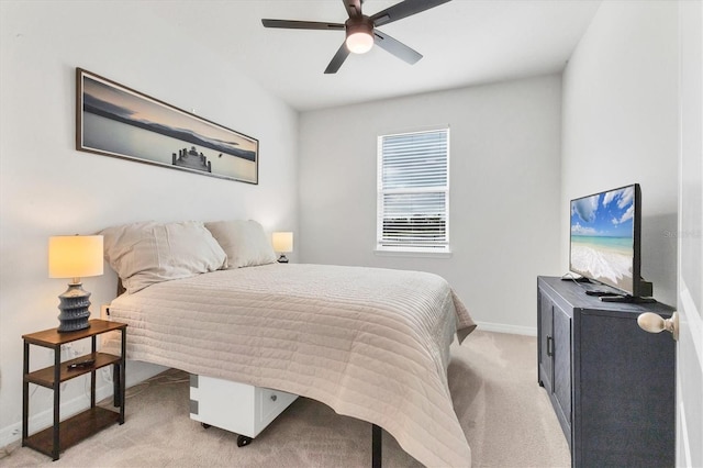 bedroom with light carpet, baseboards, and a ceiling fan