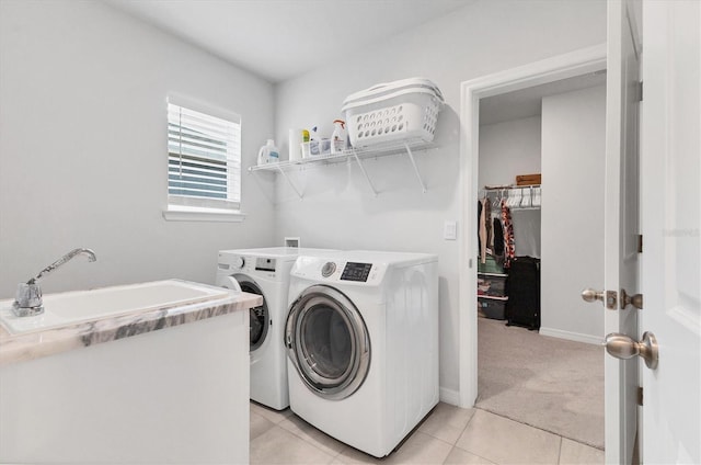 washroom with light tile patterned flooring, light carpet, laundry area, separate washer and dryer, and a sink